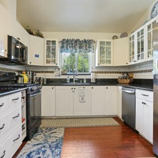 A modern kitchen with white cabinets and dark countertops.