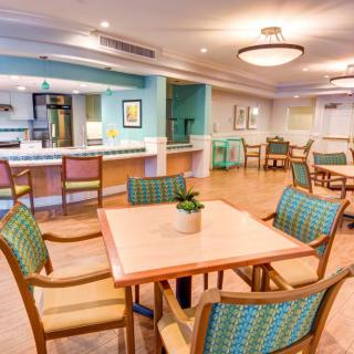 A bright and modern dining area with wooden floors, neatly arranged tables and chairs.