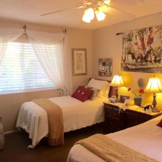 A cozy bedroom with twin beds, warm lighting, and decorative elements.