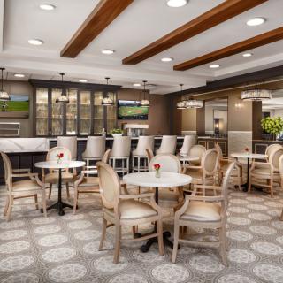 A modern restaurant interior featuring a comfortable dining area with tables, chairs, and bar seating.