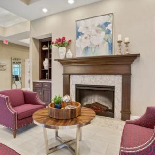 A cozy living room with a modern fireplace, plush seating, and elegant decor.
