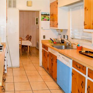 A home kitchen with wooden cabinets and a view into the dining area.