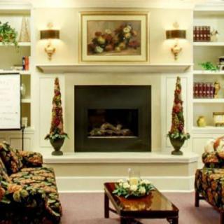 A cozy living room featuring a central fireplace with flanking sofas and elegant decor.