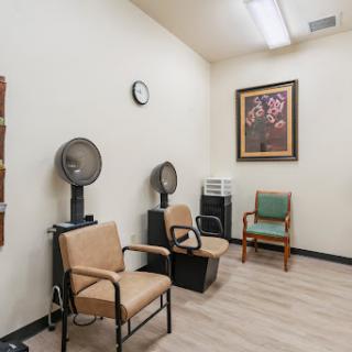 A serene waiting area in a salon, featuring comfortable chairs and hair dryers.