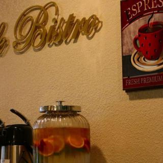 Cozy bistro corner with a drink dispenser and espresso wall art.