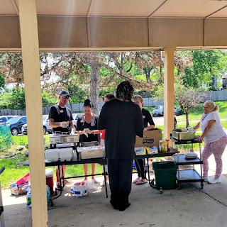 A community gathering featuring a food setup in an outdoor space.