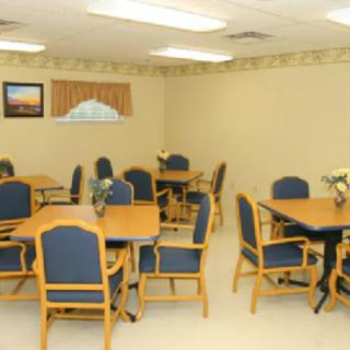 An empty dining room with tables and chairs arranged neatly.