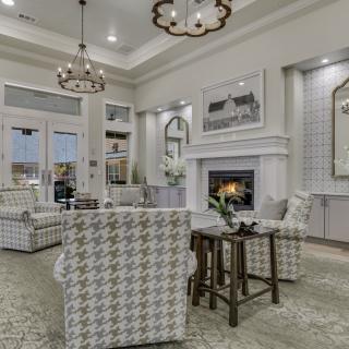 A stylish and cozy living room with elegant chandeliers, a modern fireplace, and comfortable seating.
