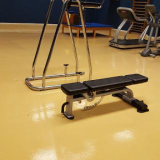 A gym setup featuring a weight bench and other exercise equipment.