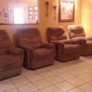 A cozy living room setup featuring multiple recliners arranged in a row.