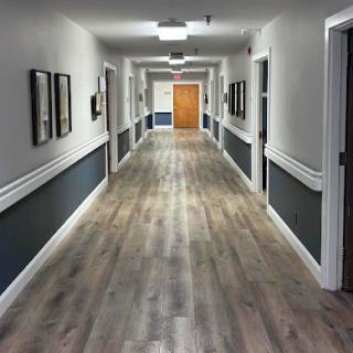 A well-lit and modern hallway featuring wooden flooring and decorative walls.