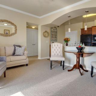 A cozy living room with elegant furniture and an open kitchen area.