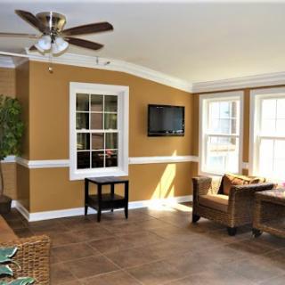 A beautifully arranged living room featuring warm brown walls and ample natural light, perfect for relaxation.