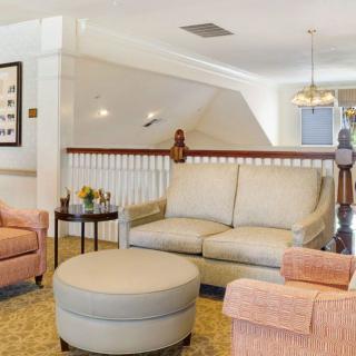 A cozy living room with a sofa, armchairs, and an ottoman arranged in a bright and airy space.