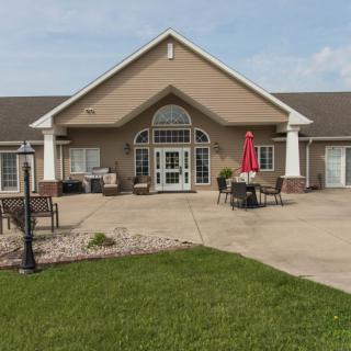 A residential building with a welcoming entrance and a patio area featuring outdoor seating.