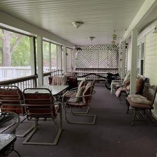 A spacious and inviting covered porch with comfortable seating, perfect for enjoying the outdoors while being sheltered.