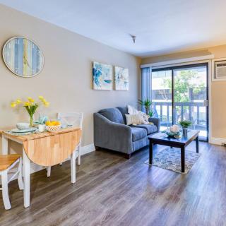 A bright and cozy living room with a small dining table set, a comfortable couch, and tasteful decor.