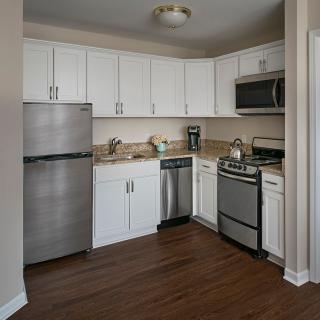 A modern kitchen with stainless steel appliances and white cabinets.