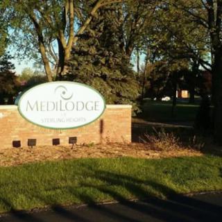 A brick sign for 'Millridge' surrounded by trees and grass.