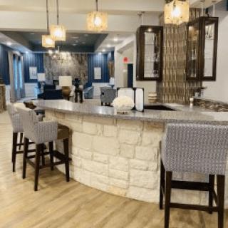A modern lounge area with a stone bar and stylish seating.