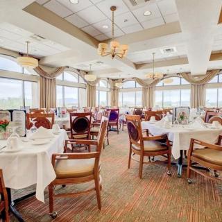 An elegant dining room with neatly arranged tables and natural lighting.