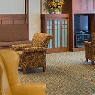 A cozy seating area in a lobby with patterned chairs and warm decor.