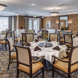 An elegantly set dining room with neatly arranged tables and chairs, creating a warm and inviting atmosphere.