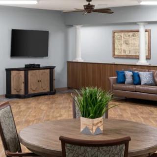 A modern living room with a stylish sofa, large television, and decorative elements like plants and artwork.