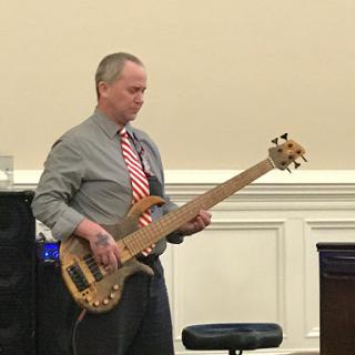 A musician performing on a bass guitar.