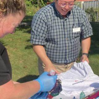 Two people engaged in a tie-dye activity outdoors.