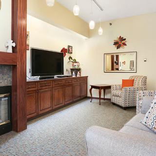 A cozy living room featuring a large television, fireplace, and comfortable seating.