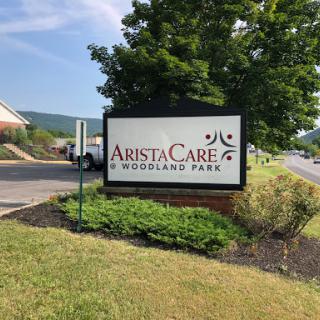 Entrance sign for AristaCare at Woodland Park, a healthcare facility.