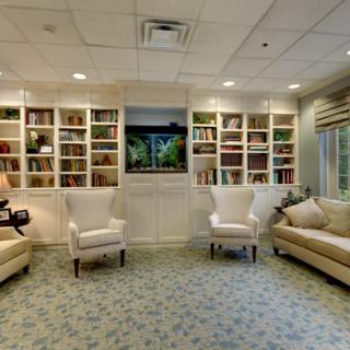 A cozy living room with bookshelves, comfortable seating, and a television.