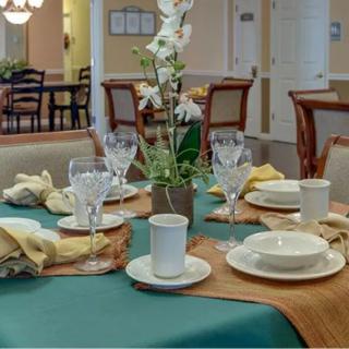 A beautifully set dining table with a floral centerpiece and elegant tableware.