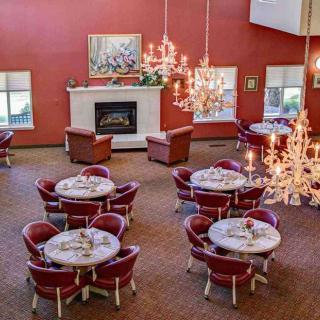 Elegant dining room with chandeliers and red walls.