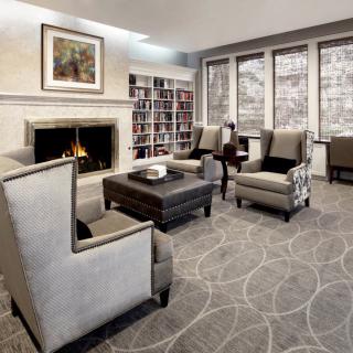 Cozy living room with a fireplace, comfortable seating, and a bookshelf.
