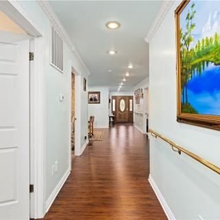 A well-lit hallway with wooden floors and colorful artwork on the walls.