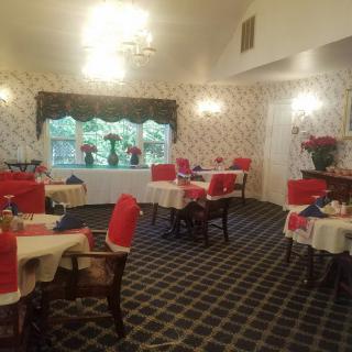 A cozy dining area with neatly arranged tables and chairs featuring red accents.