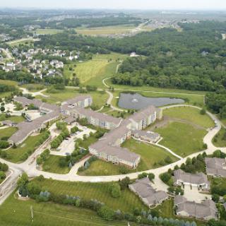 Aerial view of a suburban area featuring green spaces and developed buildings.