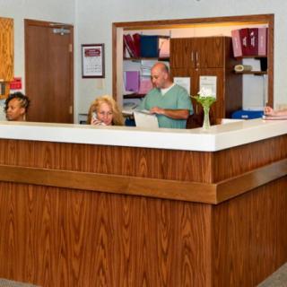 People working at a reception desk in an office setting.