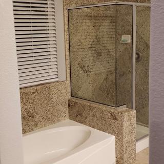 A modern bathroom featuring a bathtub and a glass-enclosed shower with tiled walls.