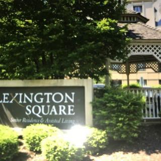 A sign for Lexington Square with a gazebo and trees in the background.