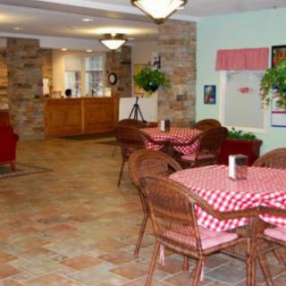 A cozy cafe with red checkered tablecloths and stone walls.