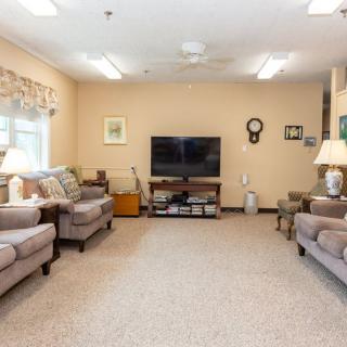 A cozy living room with ample seating and a television as the focal point.