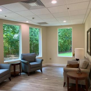 A cozy living room with comfortable chairs and large windows letting in natural light.