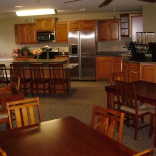 A cozy kitchen and dining area with wooden furniture and modern appliances.