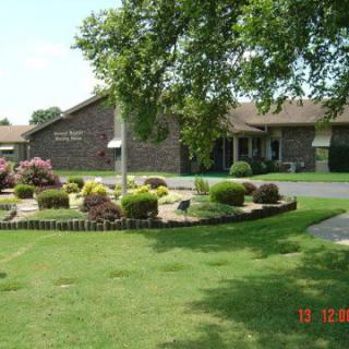 A well-maintained exterior view of a building with landscaped gardens and lush green lawns.