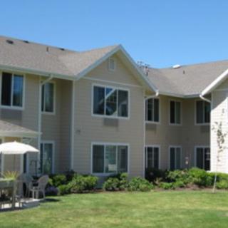 A view of a residential building with well-maintained lawn and windows.