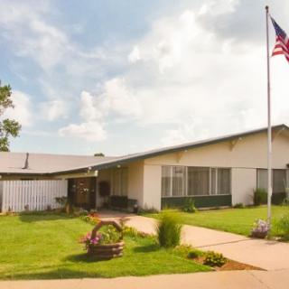 A suburban house with a well-maintained lawn and an American flag.