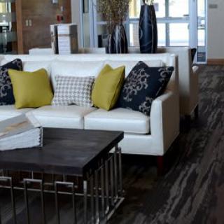 A modern living room featuring a white sofa with colorful cushions and a sleek coffee table.